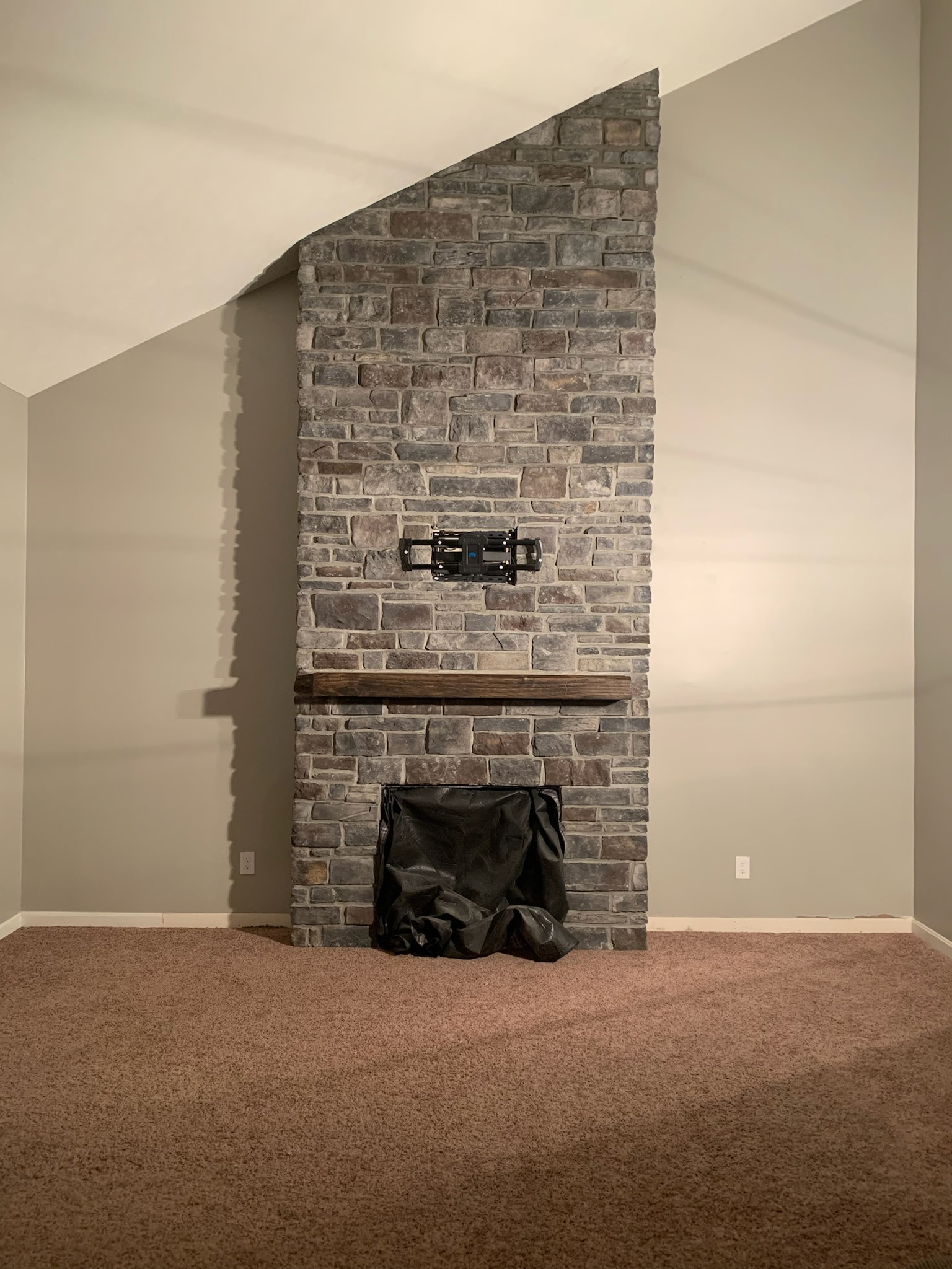 Interior stone fireplace with wood mantel